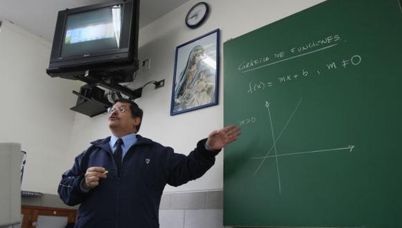 Profesor en aula con pizarra verde y televisor apagado