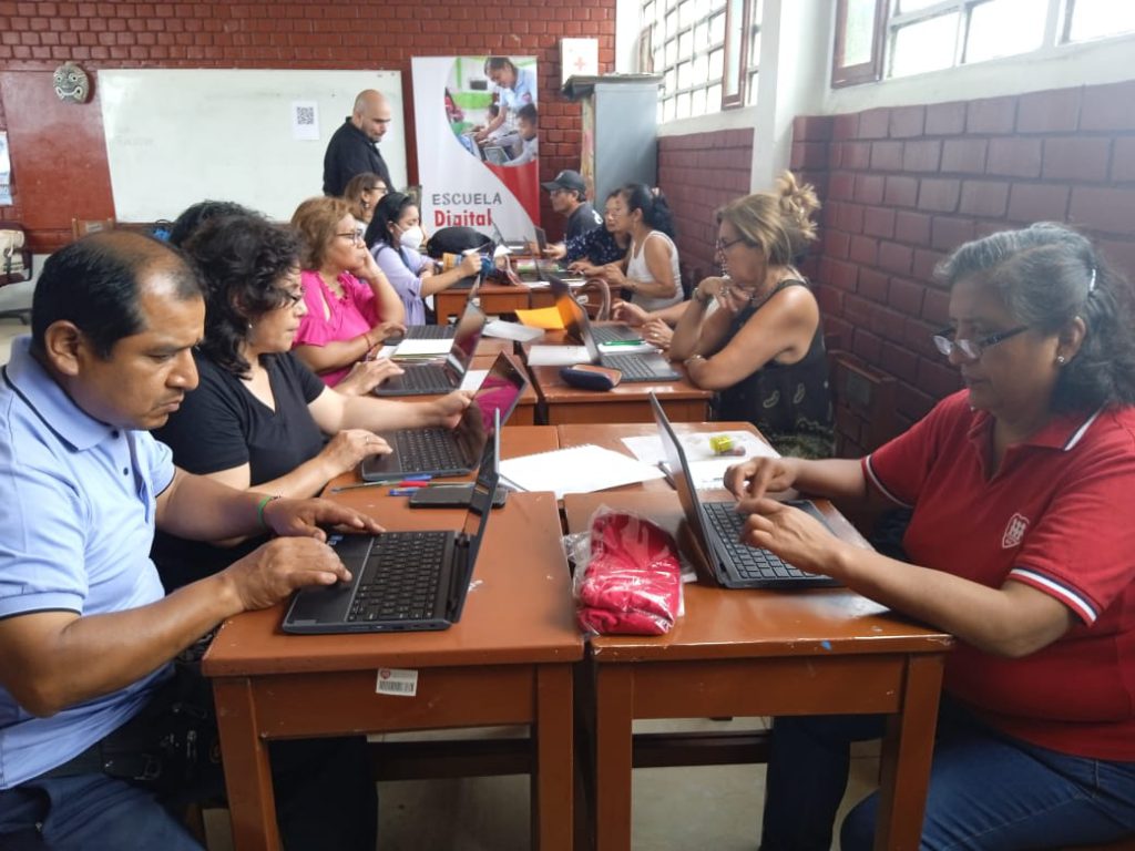 Profesores en aula llenando encuestas laptops